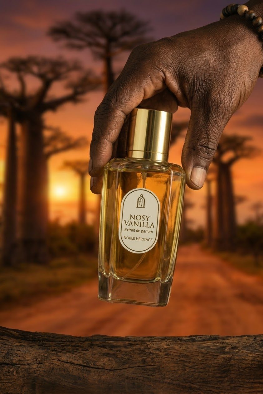 Main tenant le flacon Nosy Vanilla devant une allée de baobabs à Madagascar